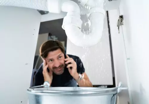 A man is seen working under a sink. Reading Plumbing is one of the Plumbing Companies in Morton IL.