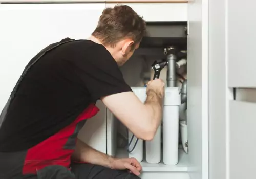 A man is seen doing maintenance. Reading Plumbing performs Water Conditioner Repair in Morton IL.