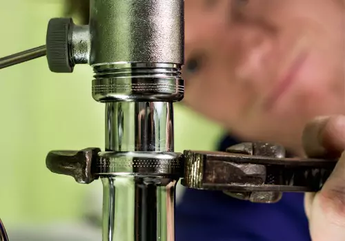 A plumber is seen working on a sink. Reading Plumbing is an emergency plumber in Washington IL.