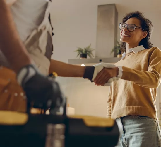 A member of Reading Plumbing greets a homeowner to discuss her sewer services needs
