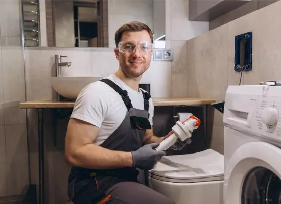 A plumber replaces a toilet filling mechanism in one of a home’s bathrooms