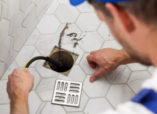 A member of Reading Plumbing unblocks a drain as part of the drain & fixture repair Reading offers