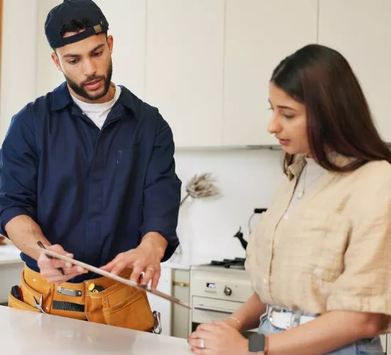 A member of Reading Plumbing goes over paperwork with a homeowner after performing drain & fixture repair