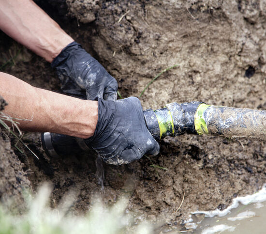 Water Heater Installation Peoria IL, Plumber Repairing a Broken Pipe in a Septic Field